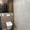 Complete toiletruimte - voorbeeld van onze showroom met; vloertegel betonlook Arca Taupe G42, Vloertegel marmerlook R70, Goude Wandtegels Martini