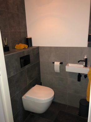 Vloertegel 30×60 cm Betonlook Ariel Antraciet NR 20 op het toilet