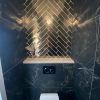 Vloertegel 60x120 cm Marmerlook Carrara Zwart Mat A83 met Wandtegel 7,5x30 cm Martini Goud RBT42 in het toilet