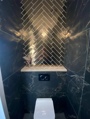 Vloertegel 60x120 cm Marmerlook Carrara Zwart Mat A83 met Wandtegel 7,5x30 cm Martini Goud RBT42 in het toilet