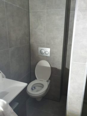 Vloertegel 60×60 cm Ariel Grijs betonlook Nr. 12 achter de wc op de wand gelegd