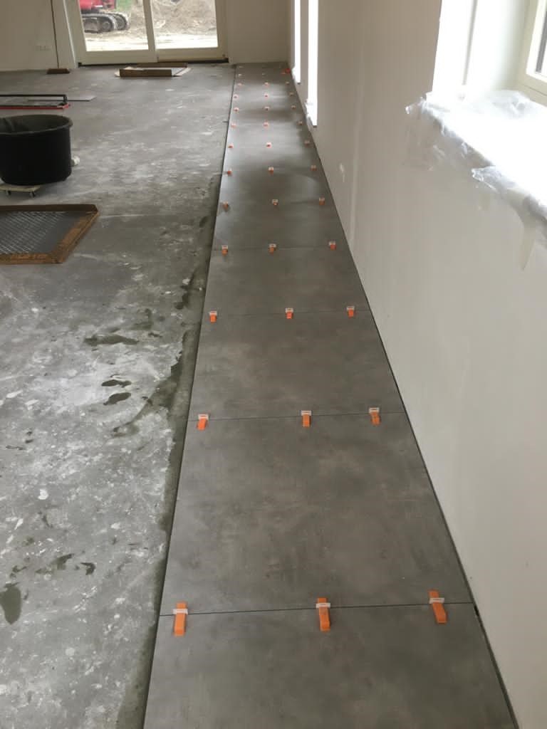 Vloertegel-60×60-cm-Betonlook-Ariel-Antraciet-NR20-2 Vloertegel 60×60 cm Betonlook Ariel Antraciet NR20 tijdens het legproces.