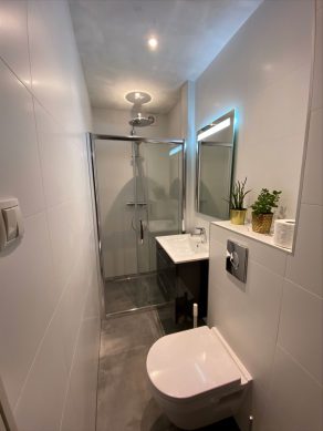 Vloertegel 60×60 cm Maddof Antraciet betonlook NR99 in de badkamer gecombineerd met wandtegel mat wit 30x60 cm