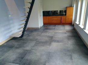 Vloertegel 80×80 cm Betonlook Antraciet DC90 in de open keuken met licht uit.