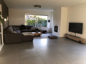 Betonlook grijs vloertegels 75x75 cm in de woonkamer gelegd
